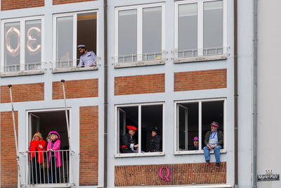 People standing by window of building