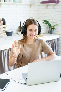 Mid adult woman using laptop on table