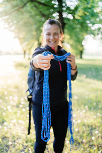 Portrait of happy woman holding a blue rope. 