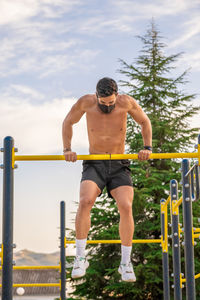 Full length of shirtless man against railing