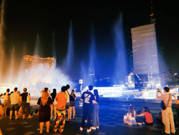 Panoramic view of crowd at illuminated city at night