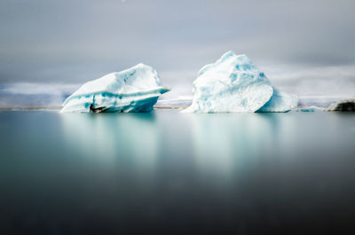 Scenic view of ice floating on sea against sky