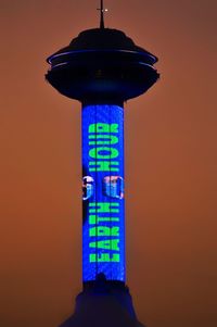 Low angle view of illuminated tower against sky at sunset