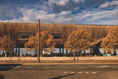 Empty road by buildings against sky