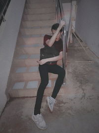 High angle view of young woman sitting on staircase at home