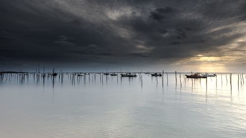 Sailboats in sea against sky during sunset