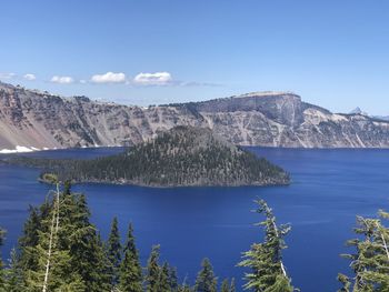 Scenic view of sea and mountains against blue sky