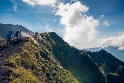 Panoramic shot of people standing on mountain against sky