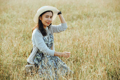 Portrait of smiling mid adult woman relaxing on grassy field