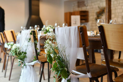 Wedding chairs decorated with white tulle and flowers