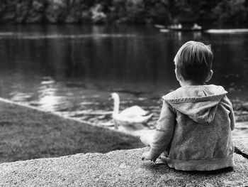 Rear view of woman standing by lake