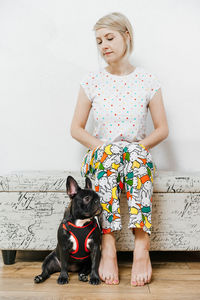 Woman sitting by dog at home