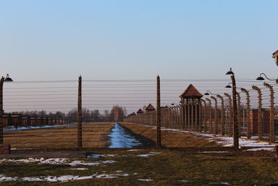 Snow covered land against clear sky during winter