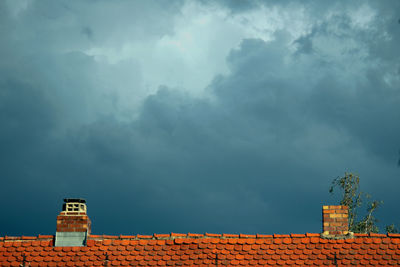 Roof of building against cloudy sky