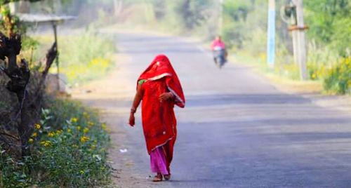 Rear view of woman standing on road