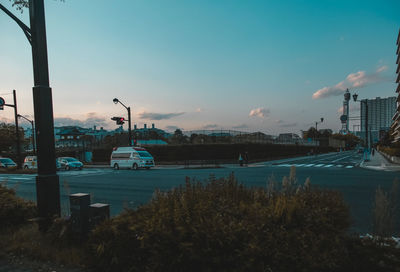 Cars on road by city against sky