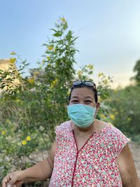 Portrait of mature woman wearing mask standing outdoors