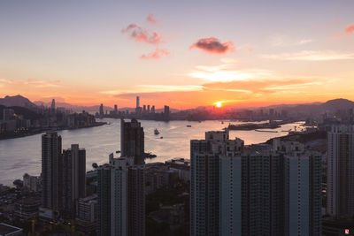 Modern buildings in city against sky during sunset