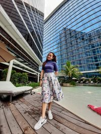 Portrait of woman standing against building