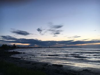 Scenic view of beach against sky at sunset