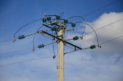 Low angle view of telephone pole against blue sky