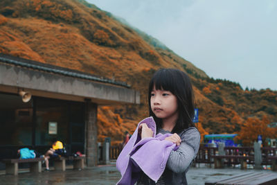 Portrait of woman standing against mountain