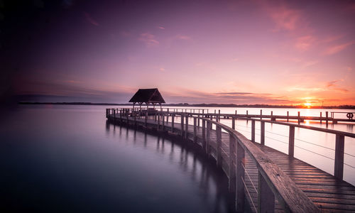 Pier over sea against sky during sunset