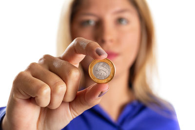 Close-up portrait of woman holding hands over white background