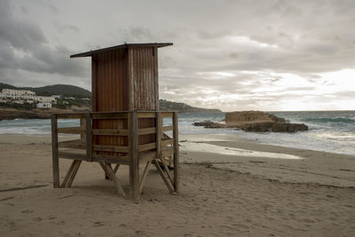 Lifeguard hut on beach against sky