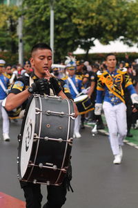 Other men play the drums in a marching band 