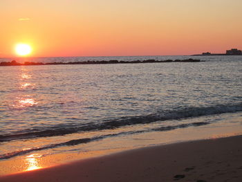 Scenic view of sea against orange sky