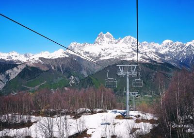 Overhead cable car over snowcapped mountains against sky