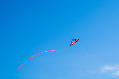 Low angle view of kite flying against blue sky