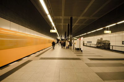 People standing at illuminated railroad station