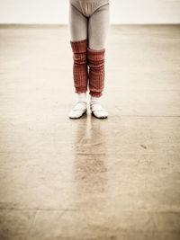 Low section of ballet dancer standing on hardwood floor