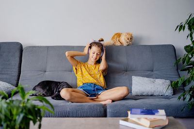 Young woman sitting on sofa at home