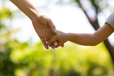 Midsection of couple holding hands