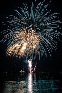 Firework display over sea at night