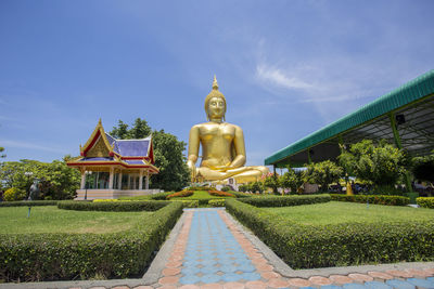 Statue of temple against building and sky