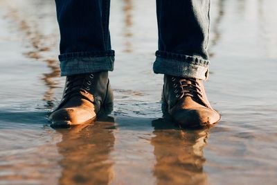 Low section of woman standing in water