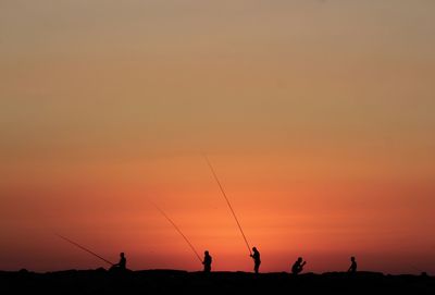 Silhouette of people fishing