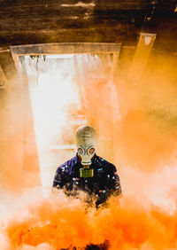 Teenage boy wearing mask amidst smoke