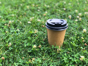 Hot paper craft cup of coffee on the grass on a morning. copy space. summer lifestyle.