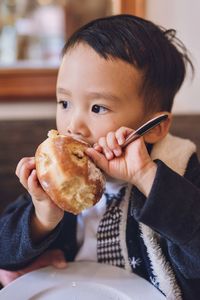 Portrait of boy eating a donut 