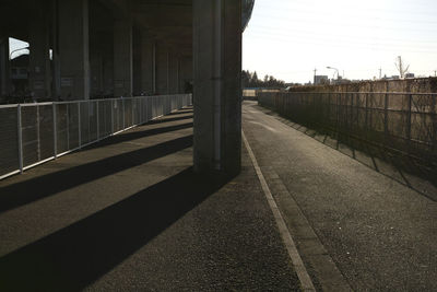 Empty road by building against sky
