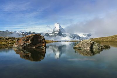 Scenic view of lake against sky during hike with a reflection of matterhorn in zermatt, switzerland