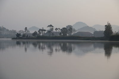 Scenic view of lake by mountains against clear sky