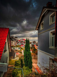 Buildings in town against cloudy sky