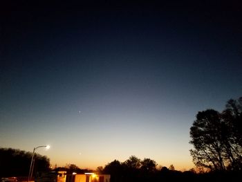 Low angle view of silhouette trees against clear sky at night