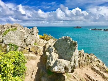 Rocks by sea against sky